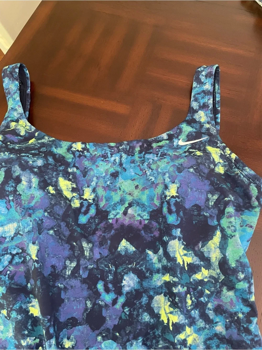 Nike women’s one piece swimsuit abstract watercolors print with a swoosh logo .